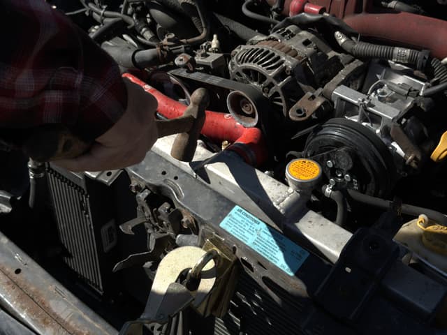Photo of issue: Top radiator hose in close contact with alternator pulley